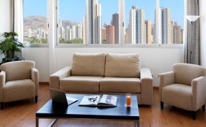 a living room with a couch and two chairs and a table at La Estación in Benidorm