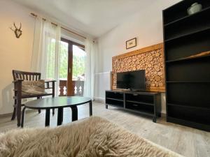 a living room with a tv and a table at Ferienwohnung Almblick in Reit im Winkl