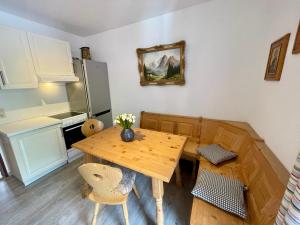 a kitchen with a wooden table and a refrigerator at Ferienwohnung Almblick in Reit im Winkl