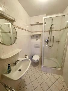 a bathroom with a sink and a shower and a toilet at Ferienwohnung Almblick in Reit im Winkl +3 photos