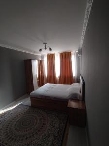 a small bedroom with a bed and a window at 2-х комнатная квартира in Qyzylorda
