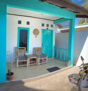 a porch with two chairs and a blue door at Salt Life Gili Trawangan in Gili Trawangan