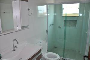 W łazience znajduje się toaleta i przeszklony prysznic. w obiekcie Apto com 3 quartos,1 vaga garagem e quintal w mieście Poços de Caldas