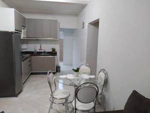 eine Küche mit einem Tisch und Stühlen im Zimmer in der Unterkunft Apto com 3 quartos,1 vaga garagem e quintal in Poços de Caldas