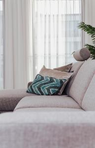 un sofá con almohadas en la sala de estar en CH Longstay 2, en Cortrique