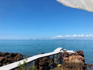 a wooden walkway over the water on a cliff at Rock View Terrace in Ko Jum