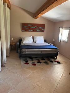 a bedroom with a bed with blue sheets and a rug at Domaine de La Font des Pères - Teritoria in Le Beausset