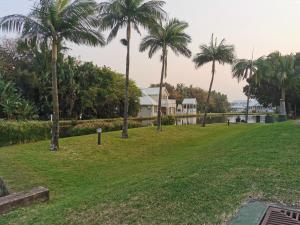 Blick auf ein Haus mit Palmen in der Unterkunft Tortuga 22 - Caribbean Estates in Port Edward