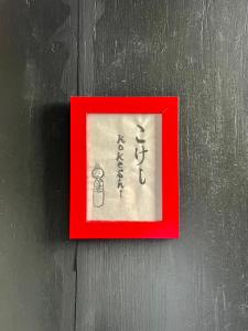 une photo d'un signe dans un cadre rouge sur une paroi dans l'établissement Maison K, à Eu