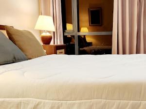 a white bed in a room with a window at Casa Antonio at Viceroy McKinley Hill in Manila