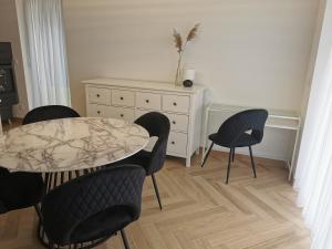 a dining room with a table and chairs and a dresser at Apartament na Irysowej in Dobrzeń Wielki