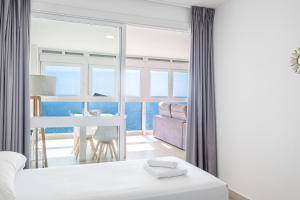 - une chambre avec un lit et une table offrant une vue sur l'océan dans l'établissement Santa Margarita Deluxe 14-B Levante Beach, à Benidorm