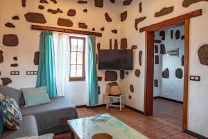 een woonkamer met een bank en een tv bij Casa Tilama in Tinajo