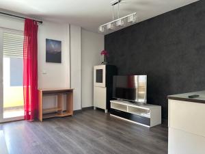 a living room with a television and a refrigerator at Piso familiar en El Toyo in Almería