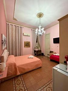 una camera rosa con letto e lampadario pendente di DayBreak B&B a Palermo
