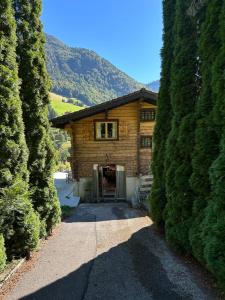 a log cabin with a door between two large trees at Chalet Flobelle in Entremont +11 photos