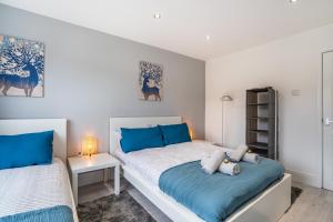 1 dormitorio con 2 camas y almohadas azules en isimi Luxurious House Newcastle 