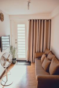 sala de estar con sofá y ventilador en AiPad Condo Rentals, en Davao City