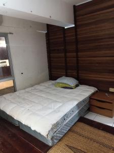 a large bed in a room with a wooden wall at Sky Chalet at Axis Next To LRT Pandan Indah Ampang in Ampang