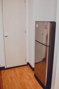 達沃市的住宿－AiPad Condo Rentals，冰箱在房间的角落