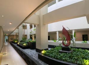 a lobby with plants and lights in a building at Savana Hotel & Convention Malang in Malang