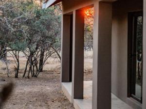 an open door of a building with trees in the background at Minara Private Boutique Game Lodge in Dinokeng Game Reserve