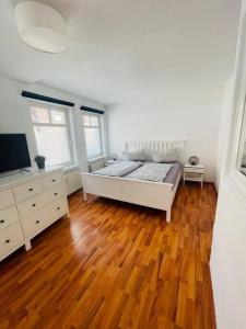 Schlafzimmer mit einem Bett und Holzboden in der Unterkunft Zentrale Altstadtkoje für bis zu 6 Personen in Neustadt in Holstein