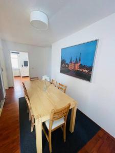 a dining room table with chairs and a painting on the wall at Zentrale Altstadtkoje für bis zu 6 Personen in Neustadt in Holstein