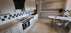 a kitchen with white cabinets and a table and a sink at Ferienwohnung Nani in Kleines Wiesental