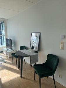 een woonkamer met een tafel en stoelen en een spiegel bij Modern and Cozy apartment with Sauna2 in Espoo