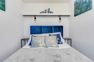a bed with a blue headboard and some pillows at Apartament Laguna Beskidów 88 przy Jeziorze Żywieckim - Dream Apart in Zarzecze