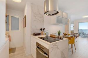 una cucina bianca con lavandino e piano cottura di Salitre Suite Tamara a Tacoronte