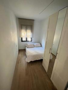 - une petite chambre avec un lit et un miroir dans l'établissement Casa Rural 2 en un Fantástico Legado, à Alfacar