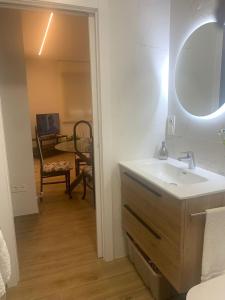 a bathroom with a sink and a mirror and a chair at Casa Rural 2 en un Fantástico Legado in Alfacar