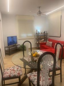- un salon avec une table, des chaises et un canapé rouge dans l'établissement Casa Rural 2 en un Fantástico Legado, à Alfacar