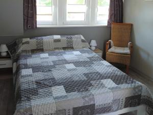 een slaapkamer met een bed met een quilt bij Haus Katharina in Barßel