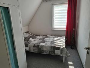 - une petite chambre avec un lit et une fenêtre dans l'établissement Haus Katharina, à Barßel
