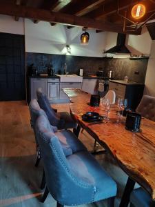 cocina con mesa de madera y sillas azules en Ty Ker Spa Brocéliande, en Saint-Malon-sur-Mel