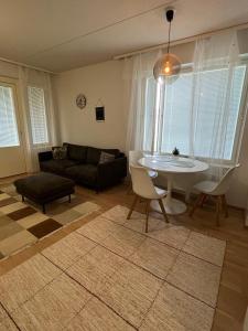 a living room with a table and a couch at Cozy Aparment with sauna nearby Airport in Vantaa