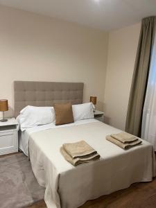 a bedroom with a large white bed with towels on it at The Garden Madrid in Madrid