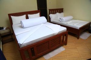 two beds with white pillows on them in a room at Johnsons Villas in Zame