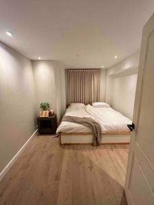 een slaapkamer met een bed en een houten vloer bij Moderne dubbele benedenwoning met 3 slaapkamers in Rotterdam