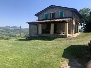 una casa en una colina con un gran patio en Casale IL SAMBUCO sui colli bolognesi, en San Lazzaro di Savena