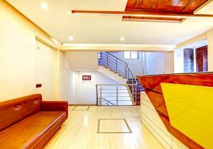 ein Wohnzimmer mit einem Sofa und einer Treppe in der Unterkunft Hotel Deepali Executive in Aurangabad