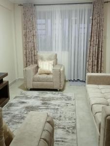 a living room with a chair and a couch at Amalya suites by TJ in Eldoret
