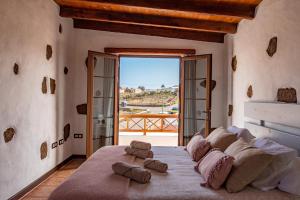 een slaapkamer met een groot bed en handdoeken bij Casa Tilama in Tinajo