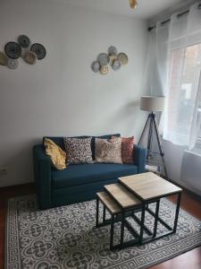 sala de estar con sofá azul y mesa en Fadil, en Valenciennes