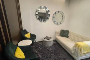 Cloud9 Waterfront Luxury Condo في المنامة: غرفة معيشة مع أريكة ومرآة