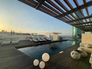 Cloud9 Waterfront Luxury Condo في المنامة: غرفة معيشة مع مسبح فوق مبنى