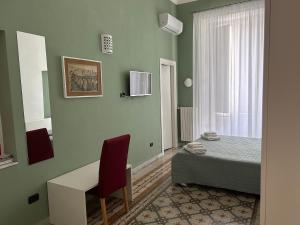 una camera con letto, scrivania e finestra di La Dimora dell' Architetto a Gravina in Puglia